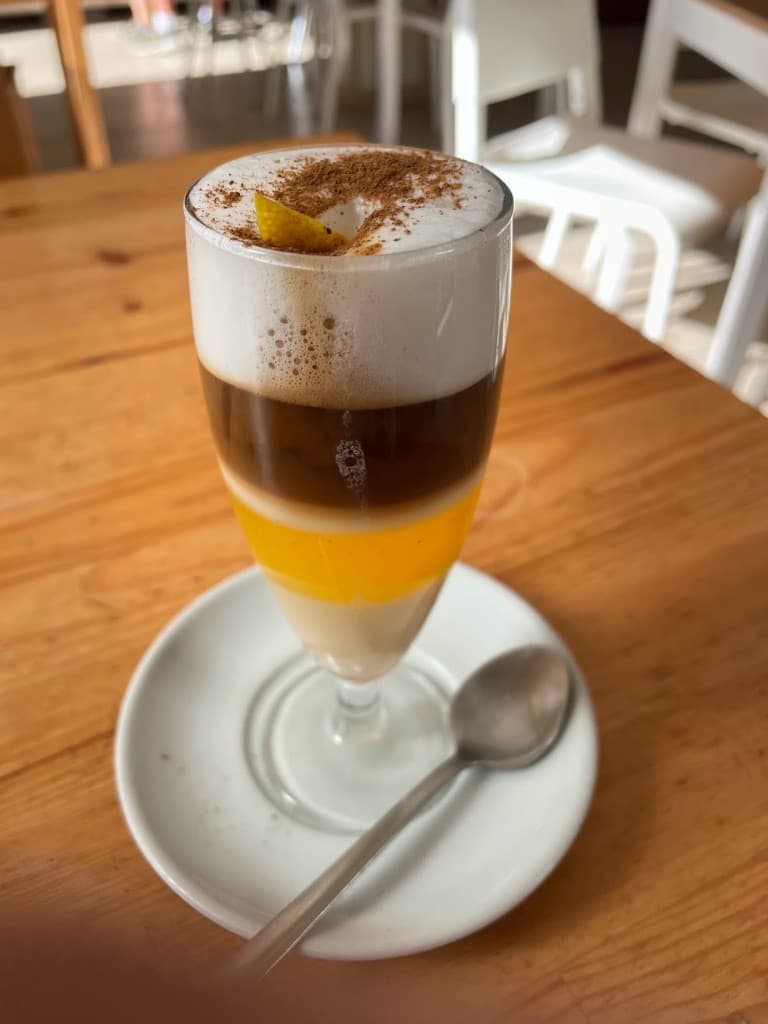 Layered coffee with foam and citrus peel