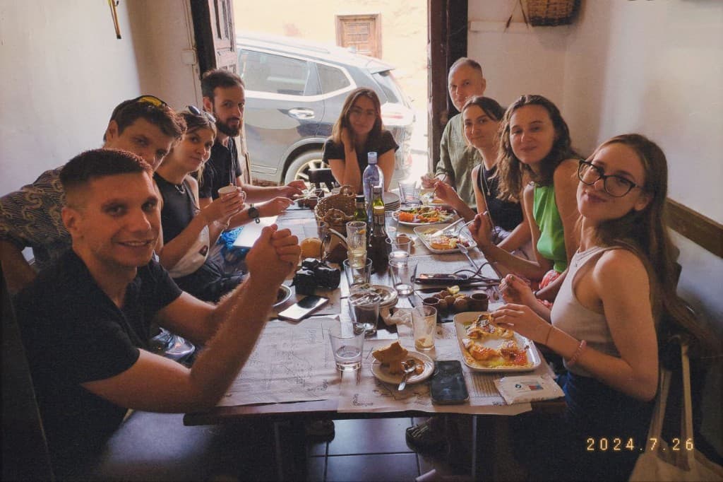 Friends sharing a meal around a long restaurant table